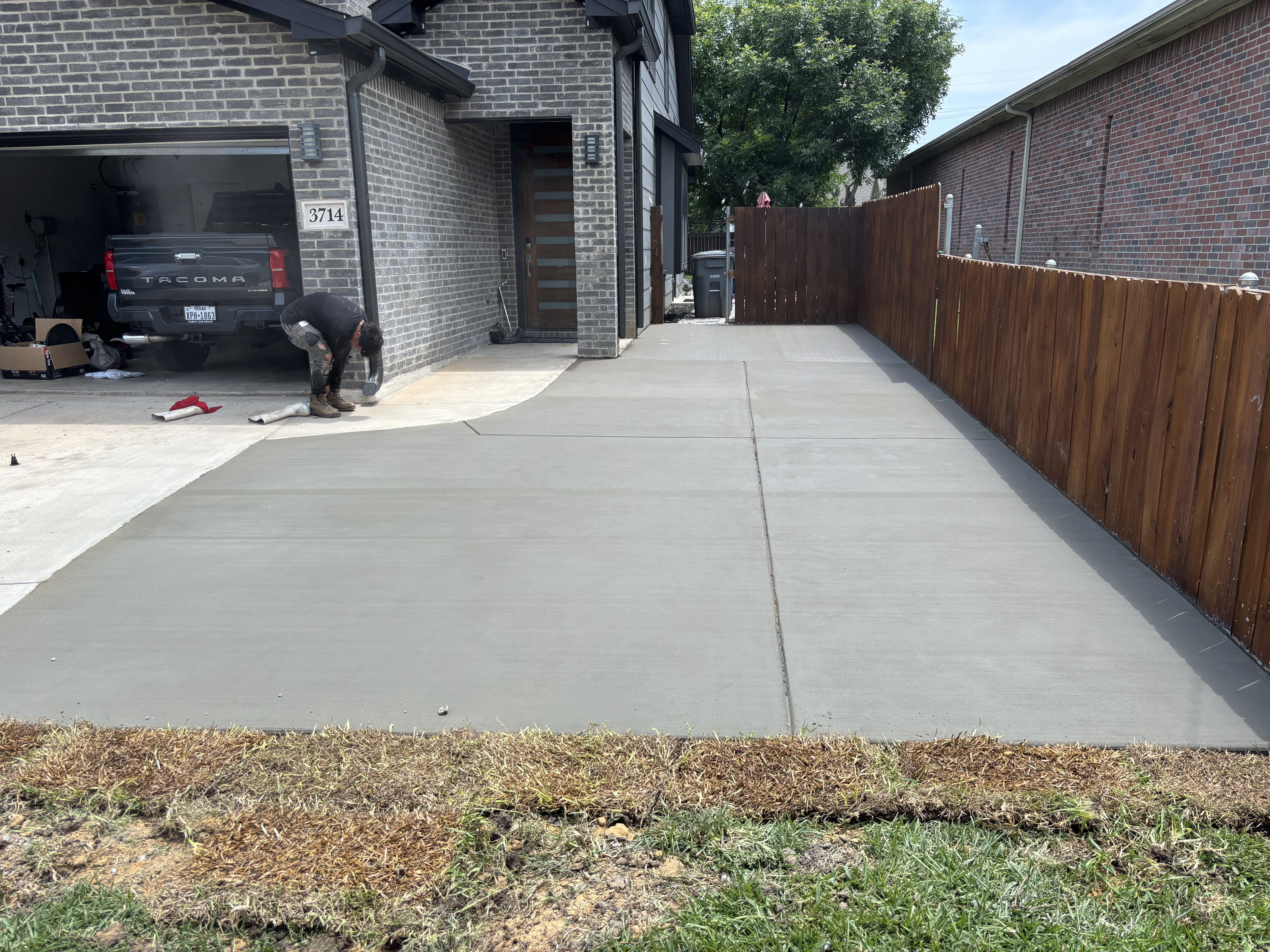 Finished concrete driveway beside a modern home